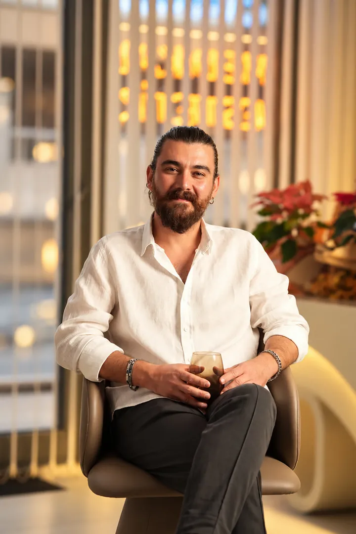 Dr. Erdem Çalışkan klinikte beyaz gömleğiyle otururken