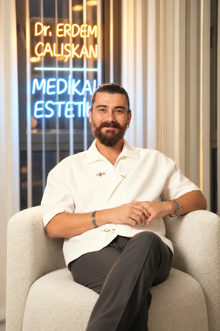 Dr. Erdem Çalışkan klinikte medikal estetik tabelasının önünde